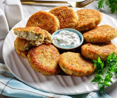 Fischfrikadellen mit Tsatsiki auf einem Teller